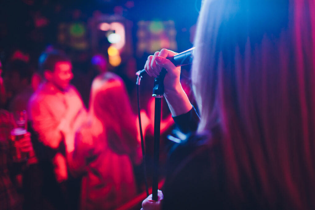 Entertainment at a wedding. A female singer is interacting with the crowd while a man plays an acoustic guitar